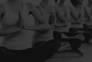 Women sitting in a Row doing Yoga Women Sitting in a Row doing Yoga